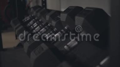 在一个现代化的体育健身房里，一排排黑色哑铃。 运动和健身。